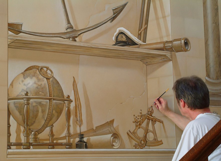 Deze muurschildering werd tot in de kleinste details uitgewerkt. Hier schildert de kunstenaar enkele zeevaartinstrumenten in een valse nis zeevaarttuigen